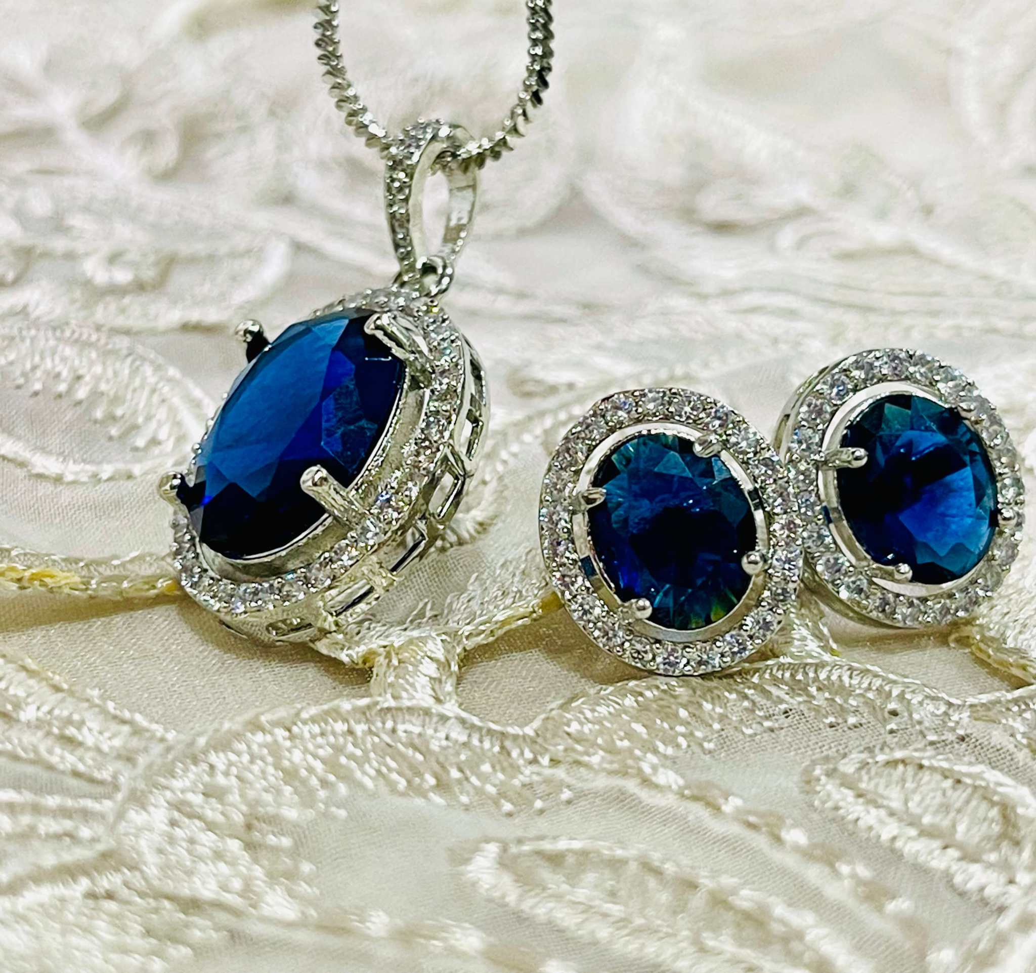 Indigo Grand Pendant Set featuring oval indigo stones surrounded by white diamonds on a silver chain and matching earrings