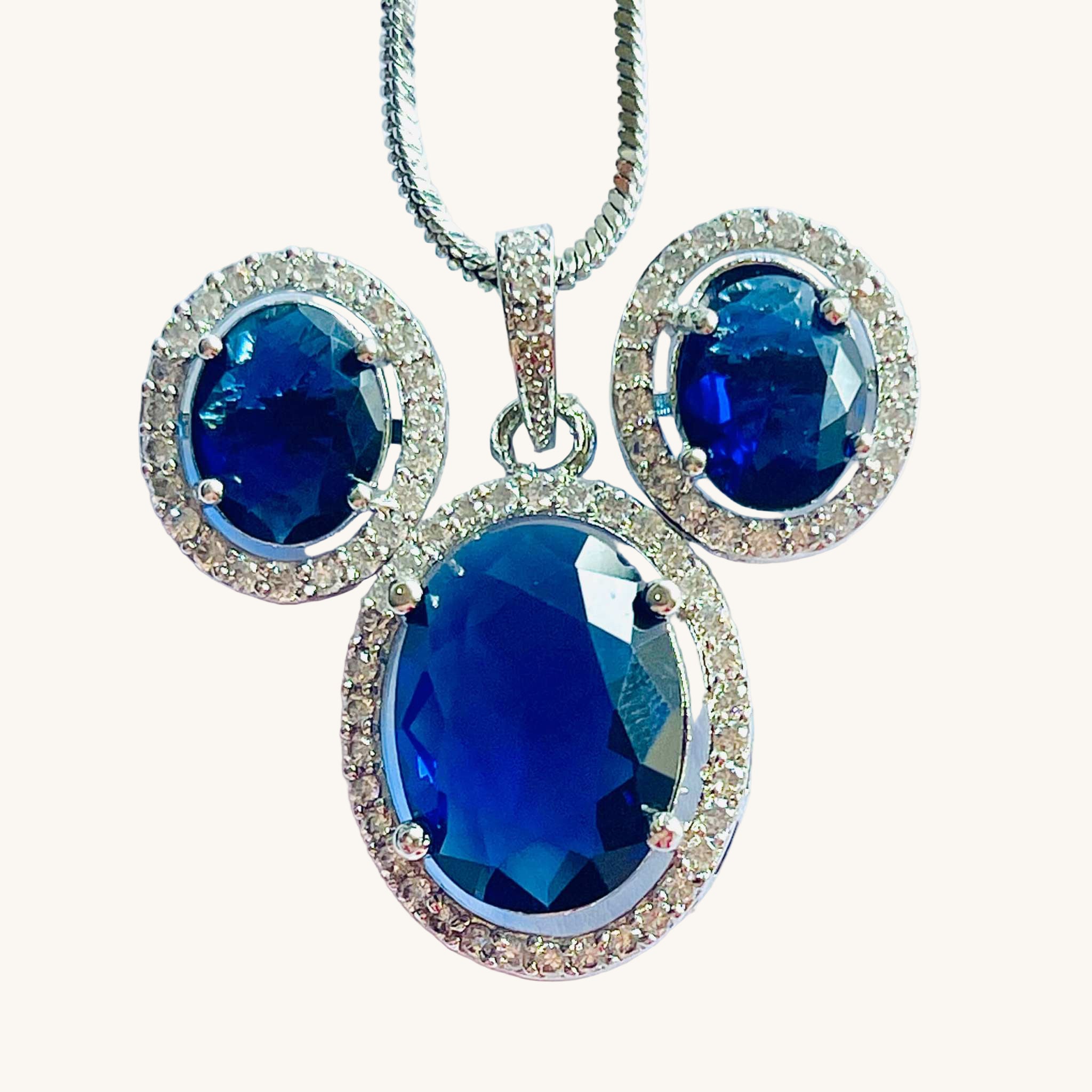 Indigo Grand Pendant Set with oval indigo stones surrounded by white diamonds on silver chain and matching earrings