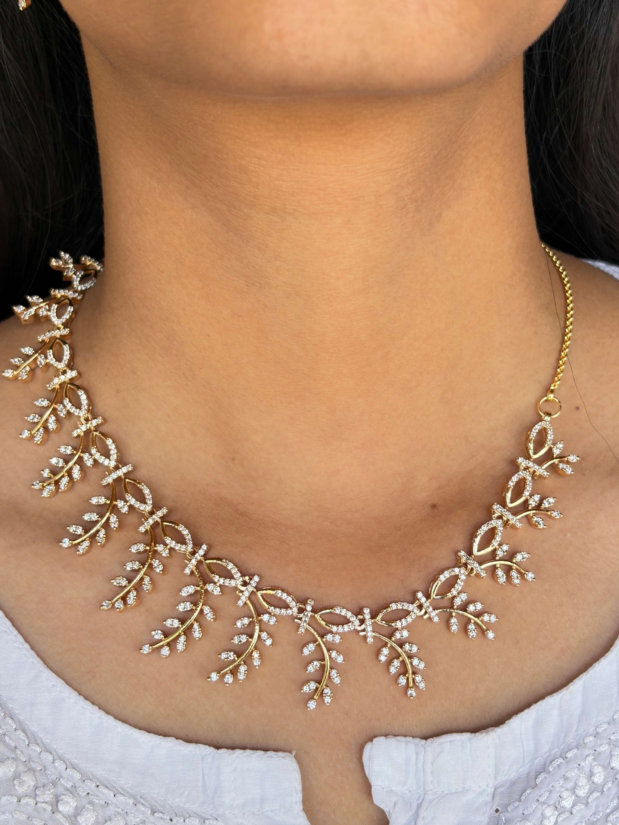 Everglow Willow Necklace Set in gold with delicate shimmering leaf design on neck