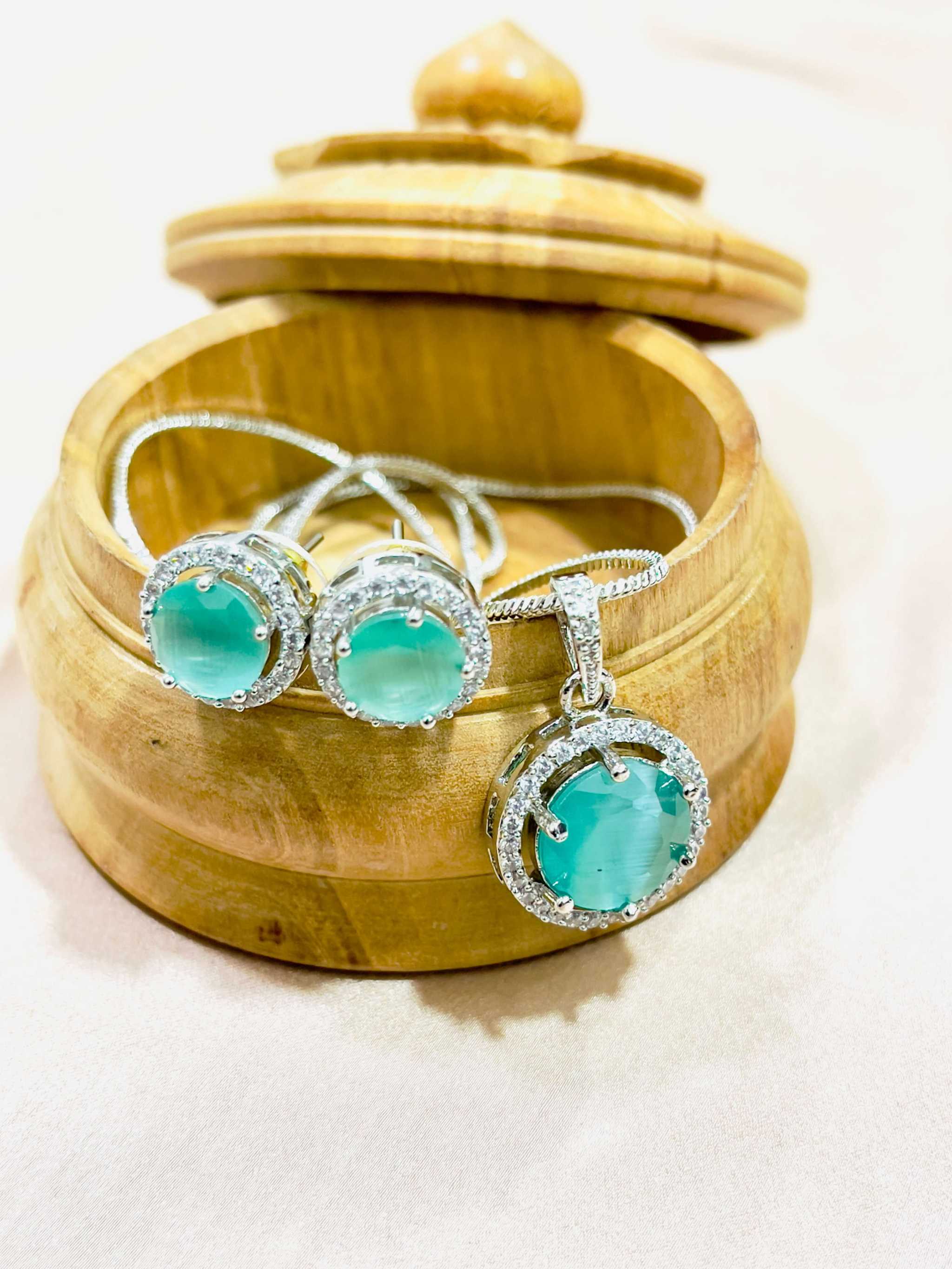 Teal Majestic Moonlit round pendant set with AD stones in silver setting displayed in wooden box