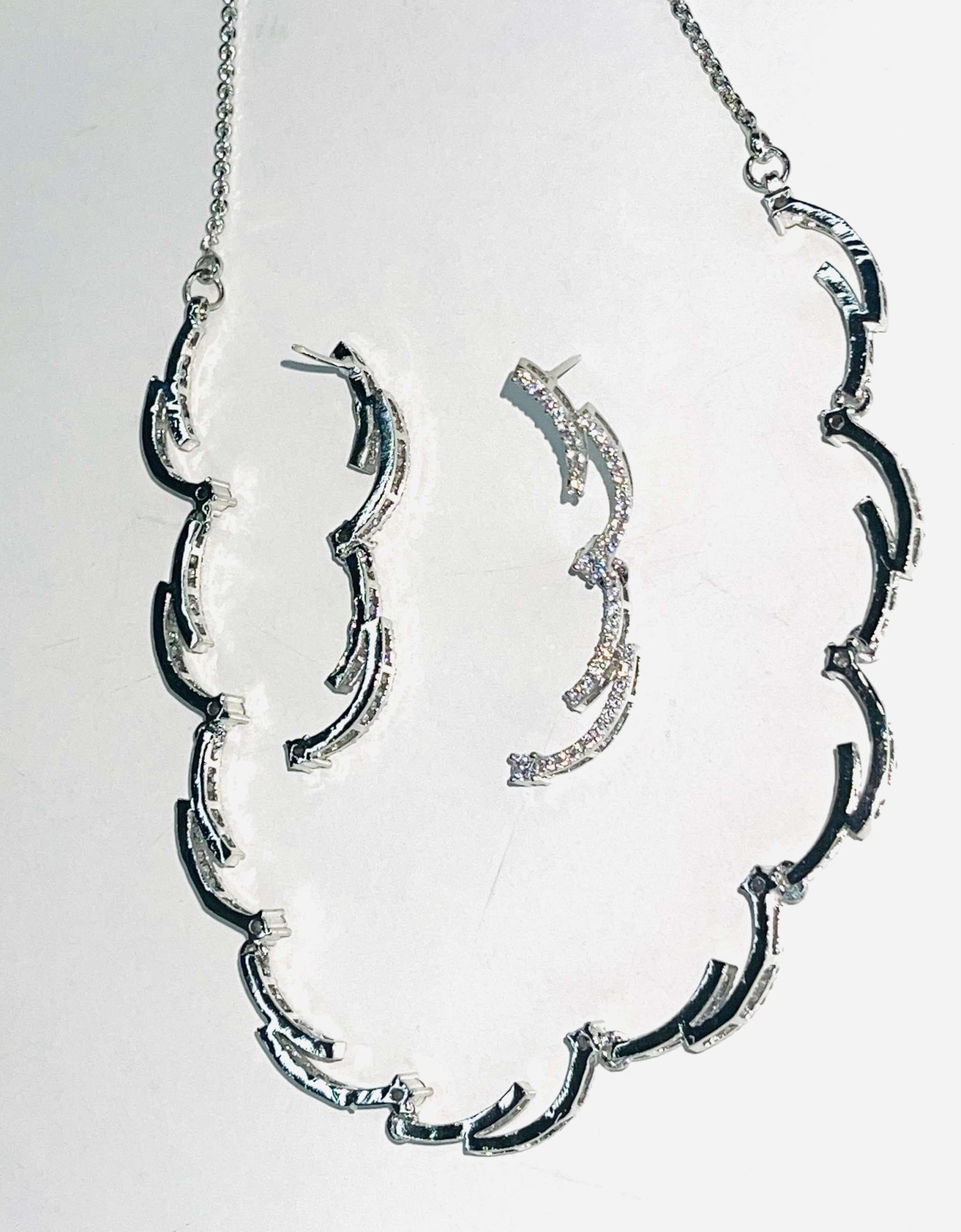 Silver crescent silhouette necklace and matching earrings set with elegant curved design