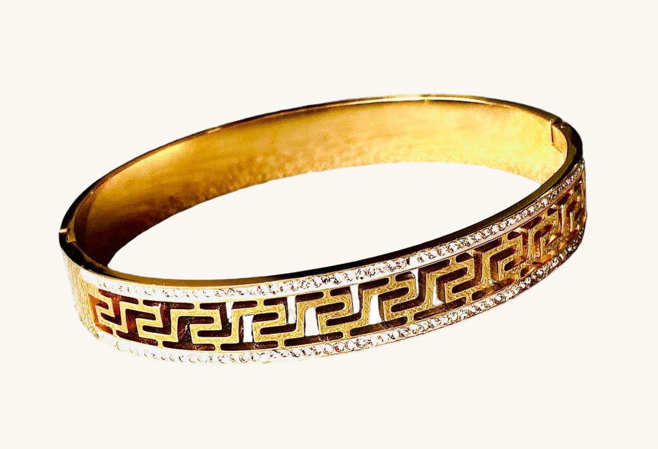 Geometric gold bracelet with intricate cut-out pattern and rhinestone accents