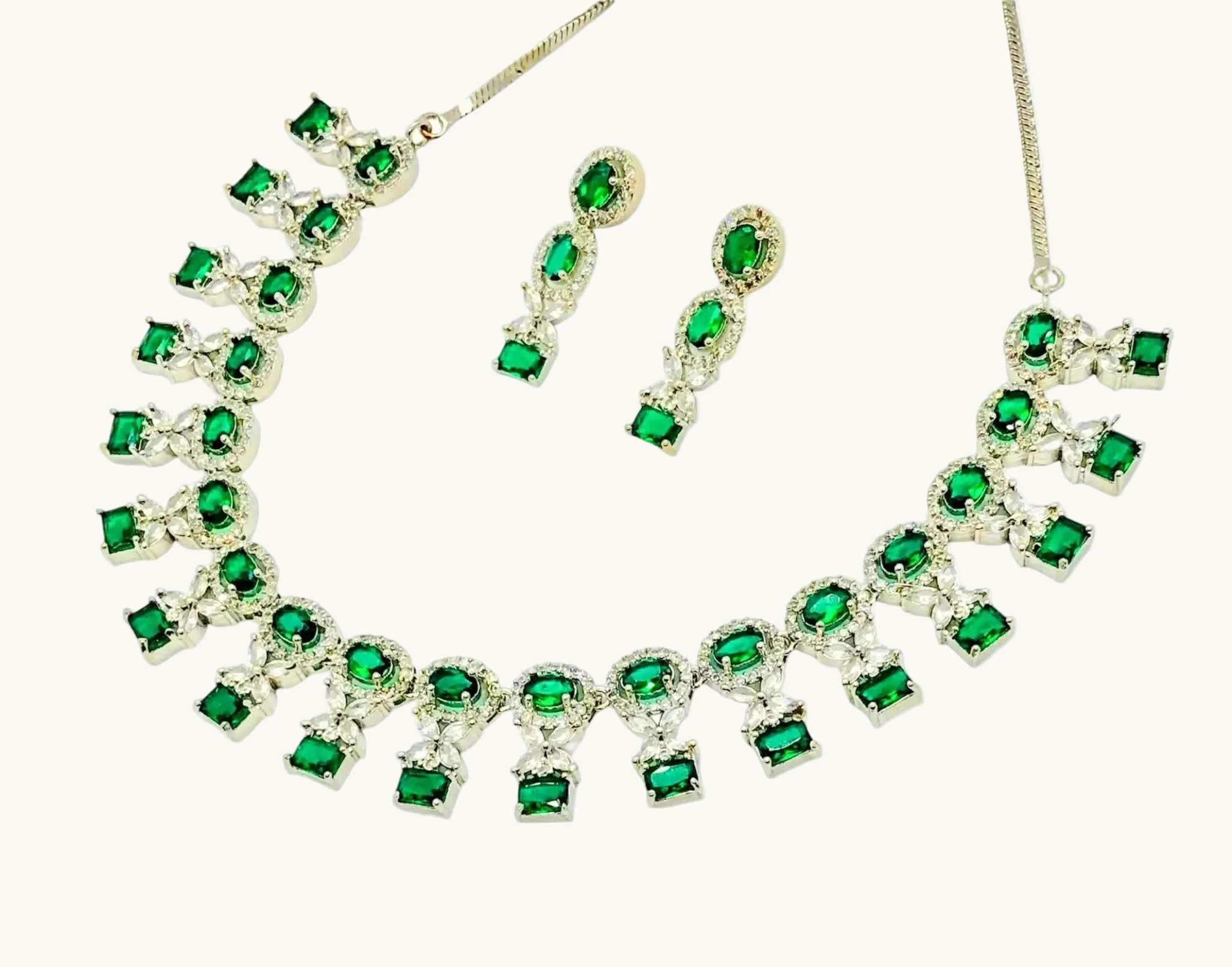 Radiant emerald necklace set with matching earrings featuring vibrant green gemstones and silver settings