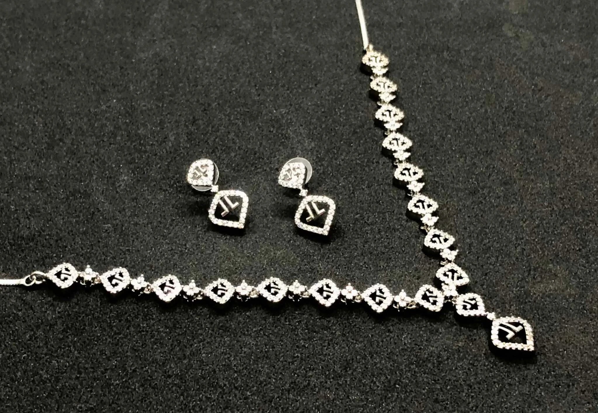 Elegant white zircon necklace and earrings set with sparkling AD stones on black background