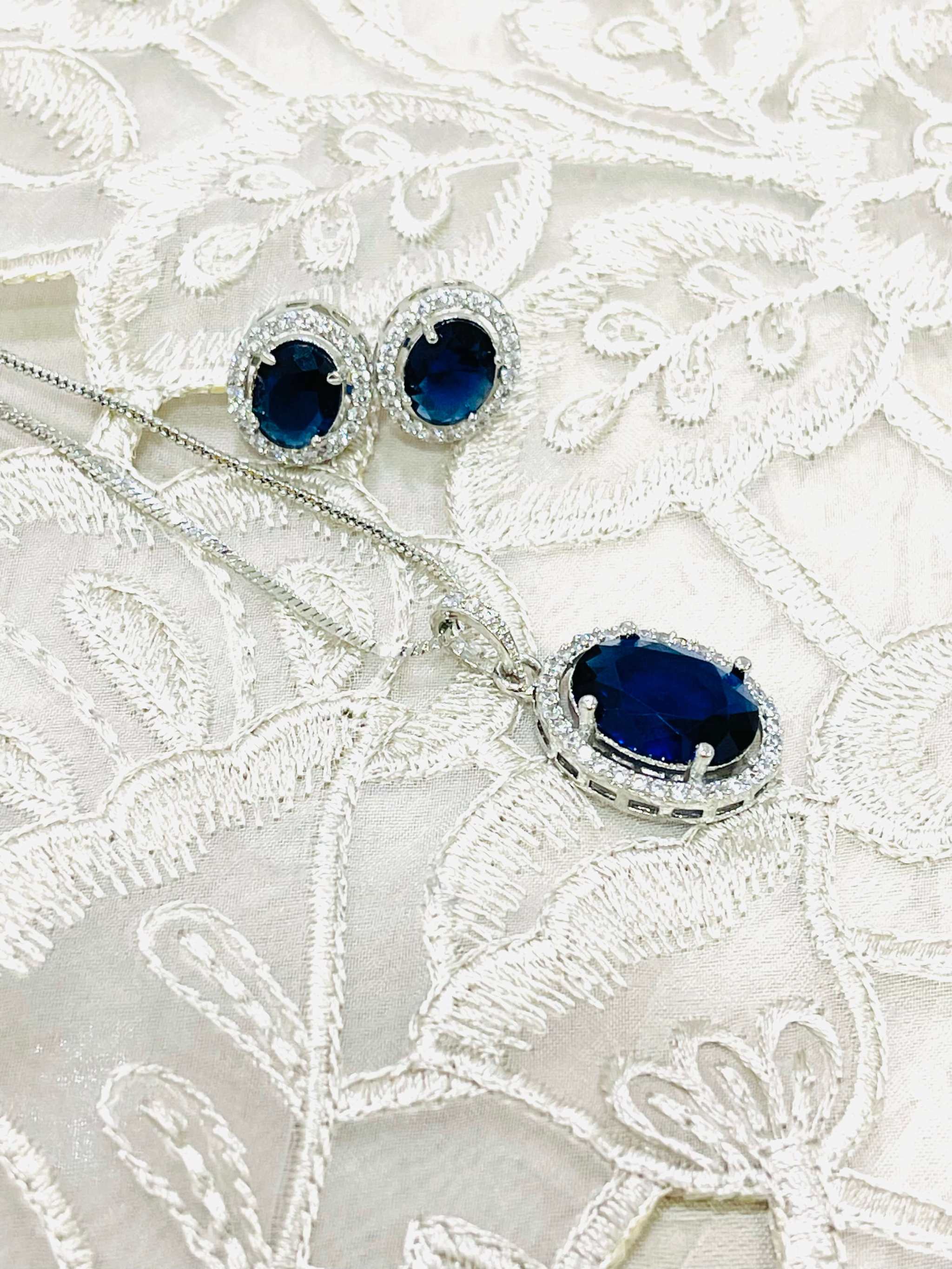 Blue and silver oval pendant set with matching earrings featuring deep blue stones and silver detailing