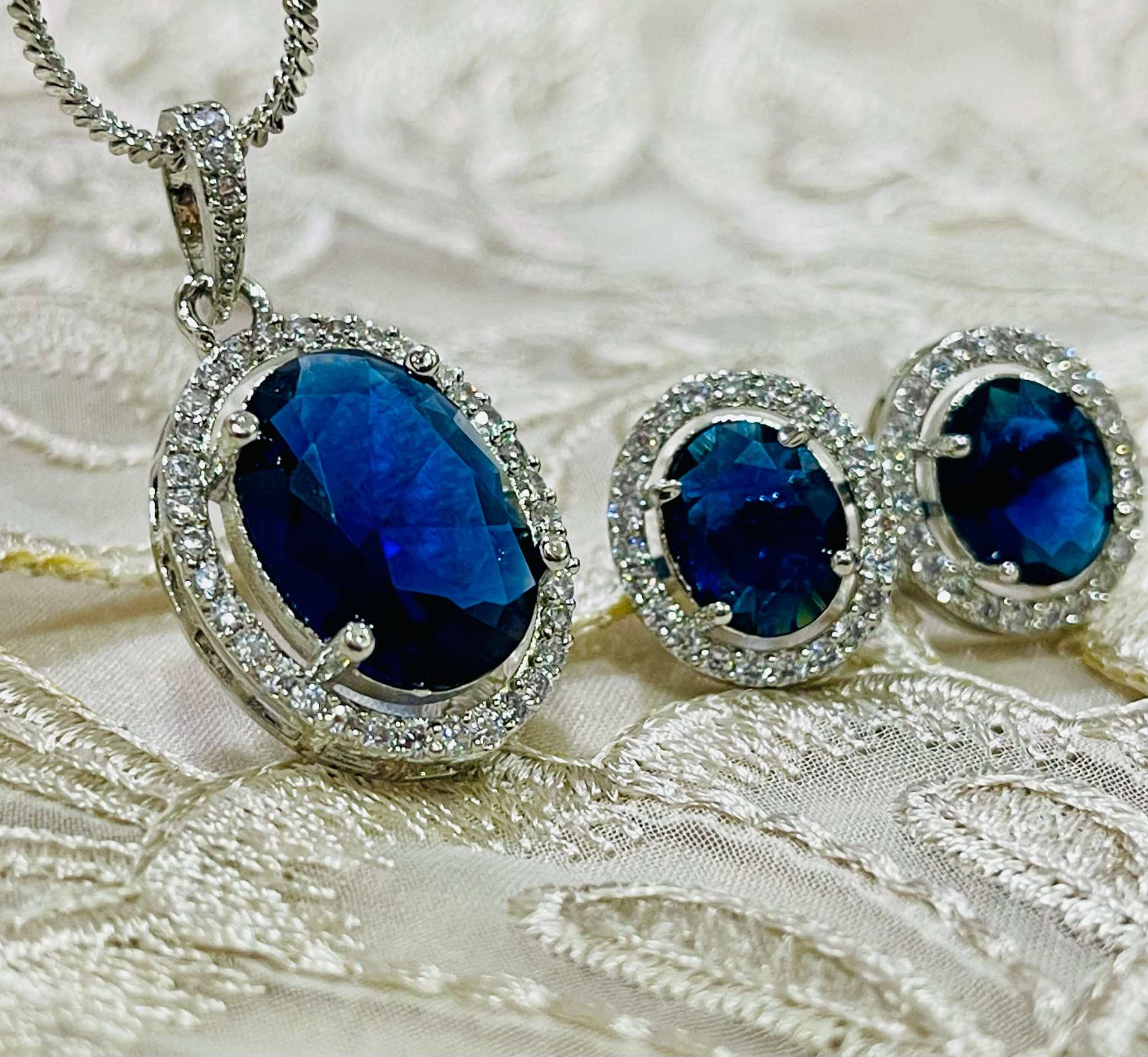 Blue and silver oval pendant and earring set with deep blue stones and surrounding clear AD stones