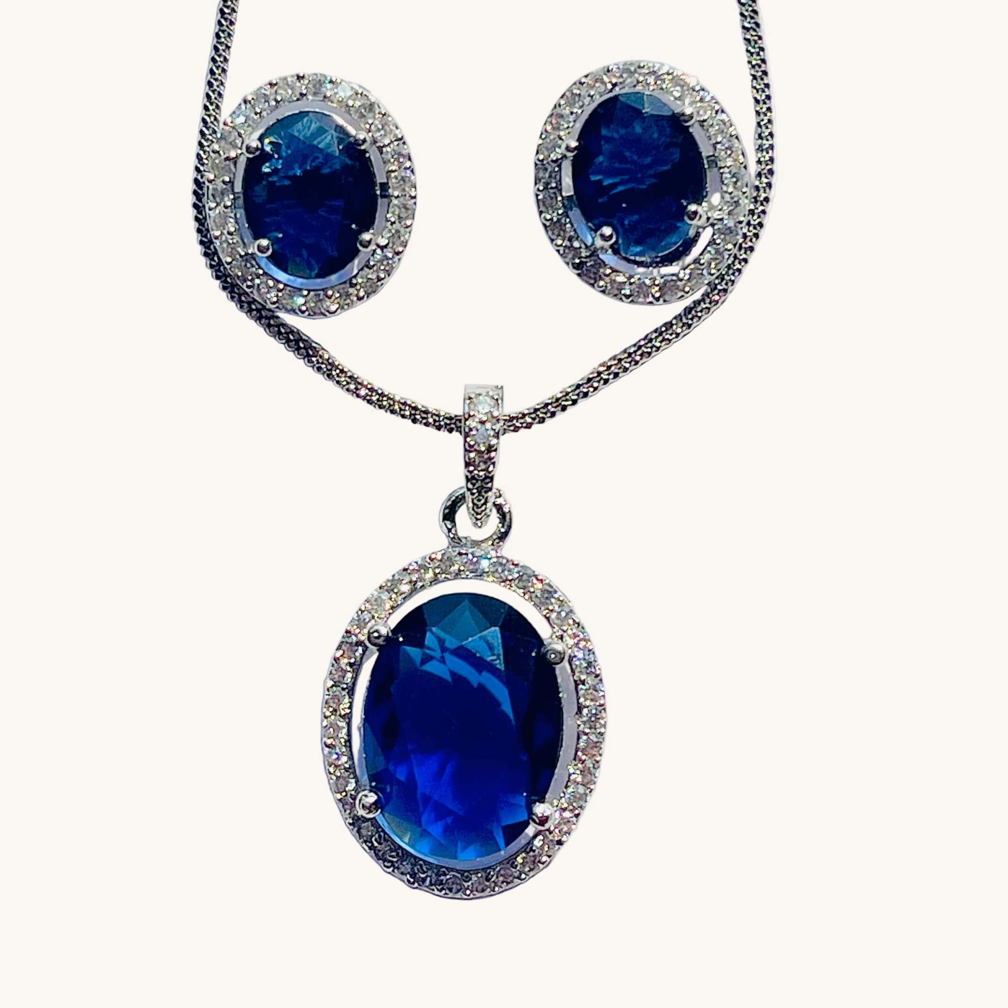 Blue and silver oval pendant and earrings set with sparkling AD stones and deep blue center gems