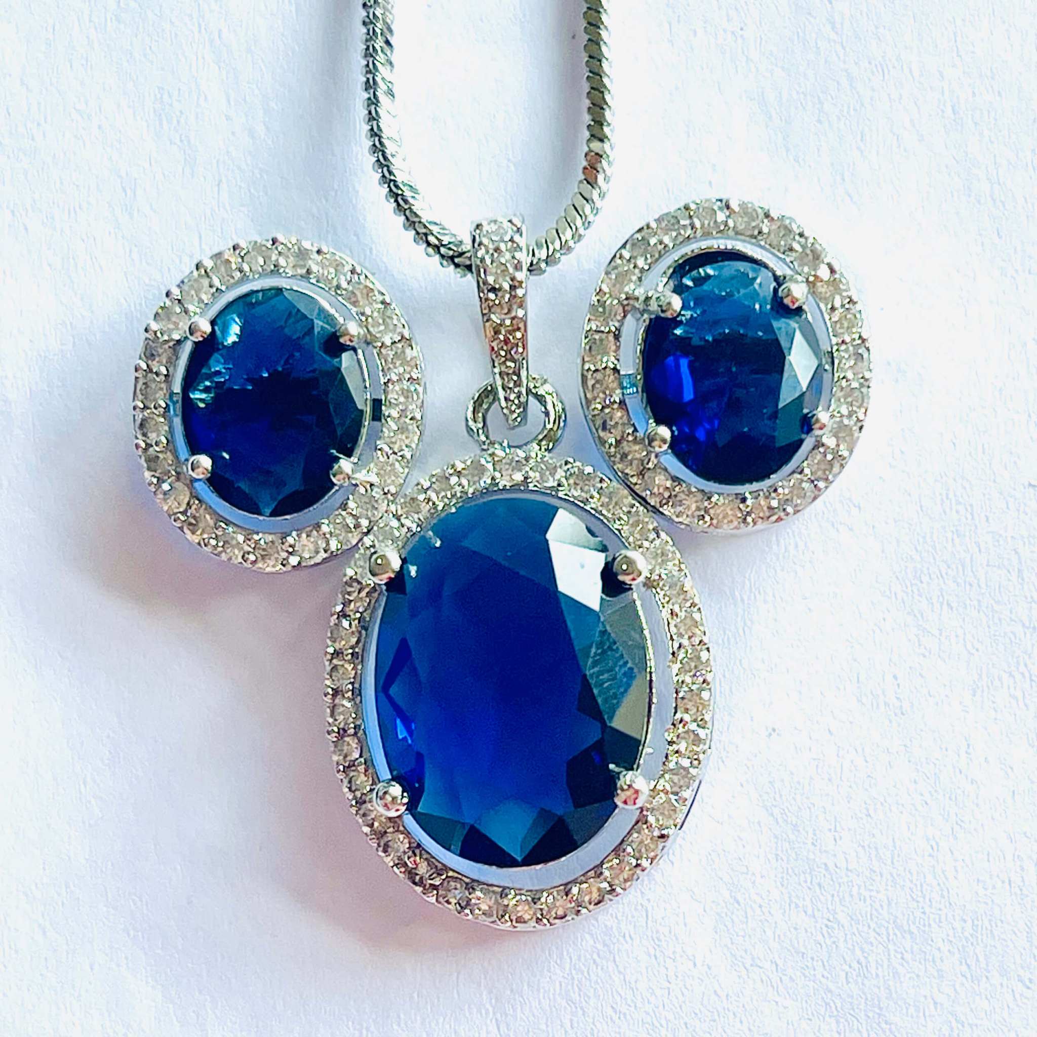 Indigo Grand Pendant Set with oval indigo stones surrounded by white diamonds on silver chain and matching earrings