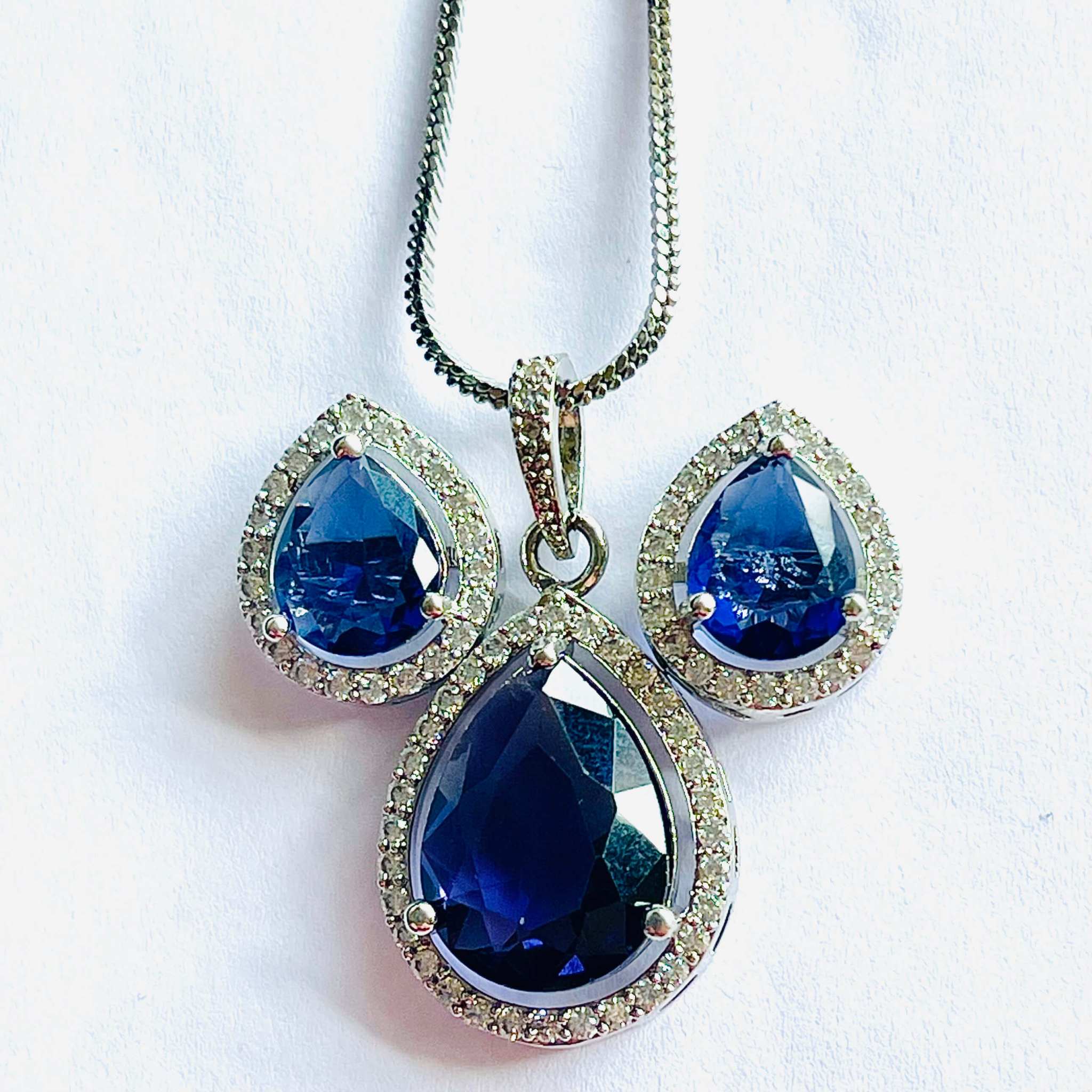 Indigo Grand Pendant Set with teardrop-shaped deep blue gemstones surrounded by small diamonds on silver chain and matching earrings