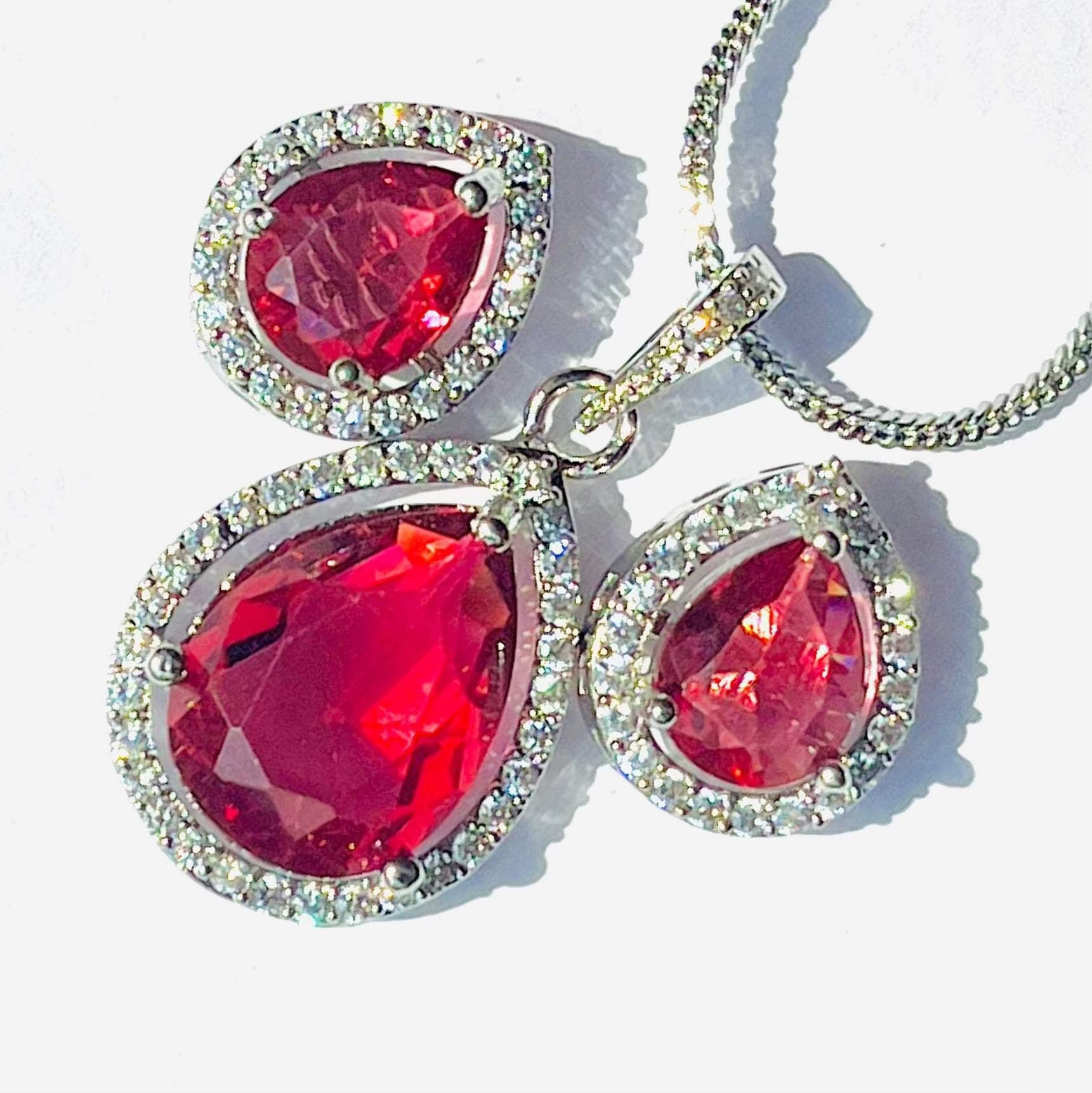 Blazing Red Aurora Drops pendant and earrings set with teardrop-shaped red gemstones surrounded by sparkling crystals
