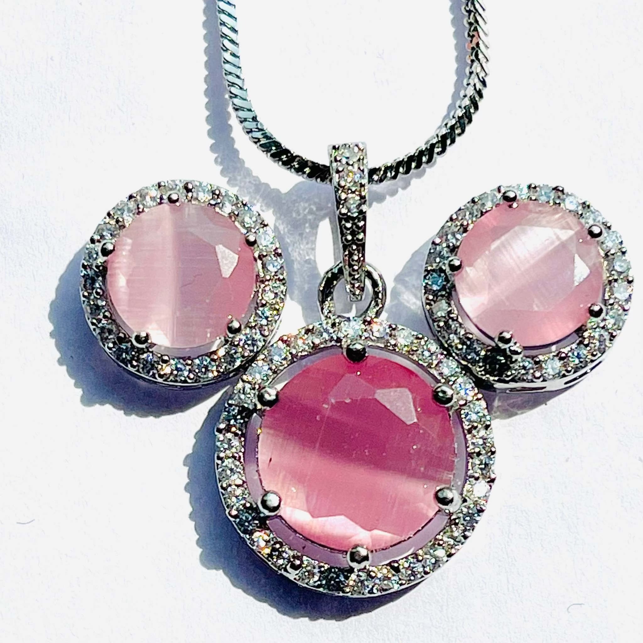 Pink Majestic Moonlit Circular pendant and earrings set with radiant pink gemstones and intricate silver detailing