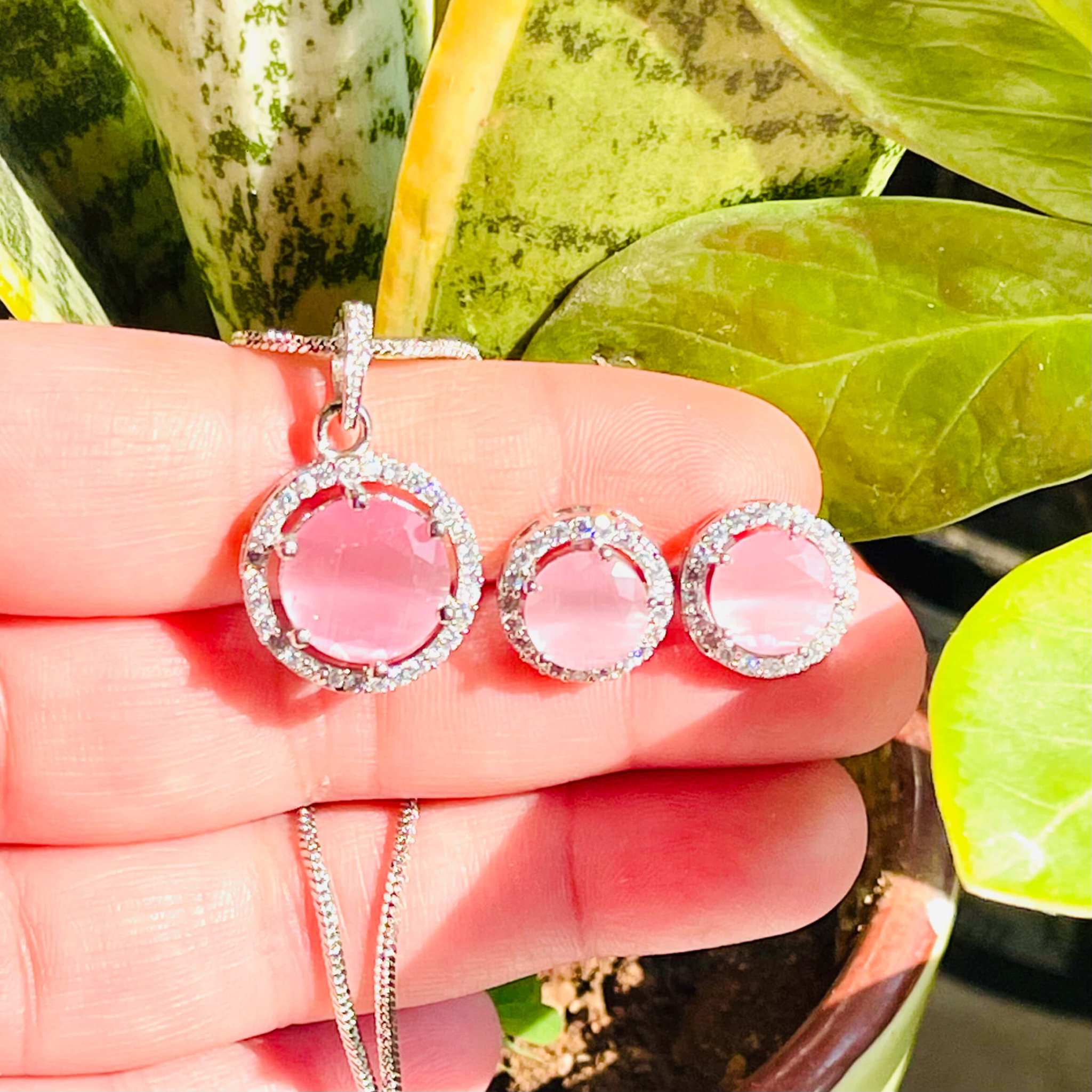 Pink Majestic Moonlit Circular pendant and earrings set with radiant pink gemstones and silver detailing