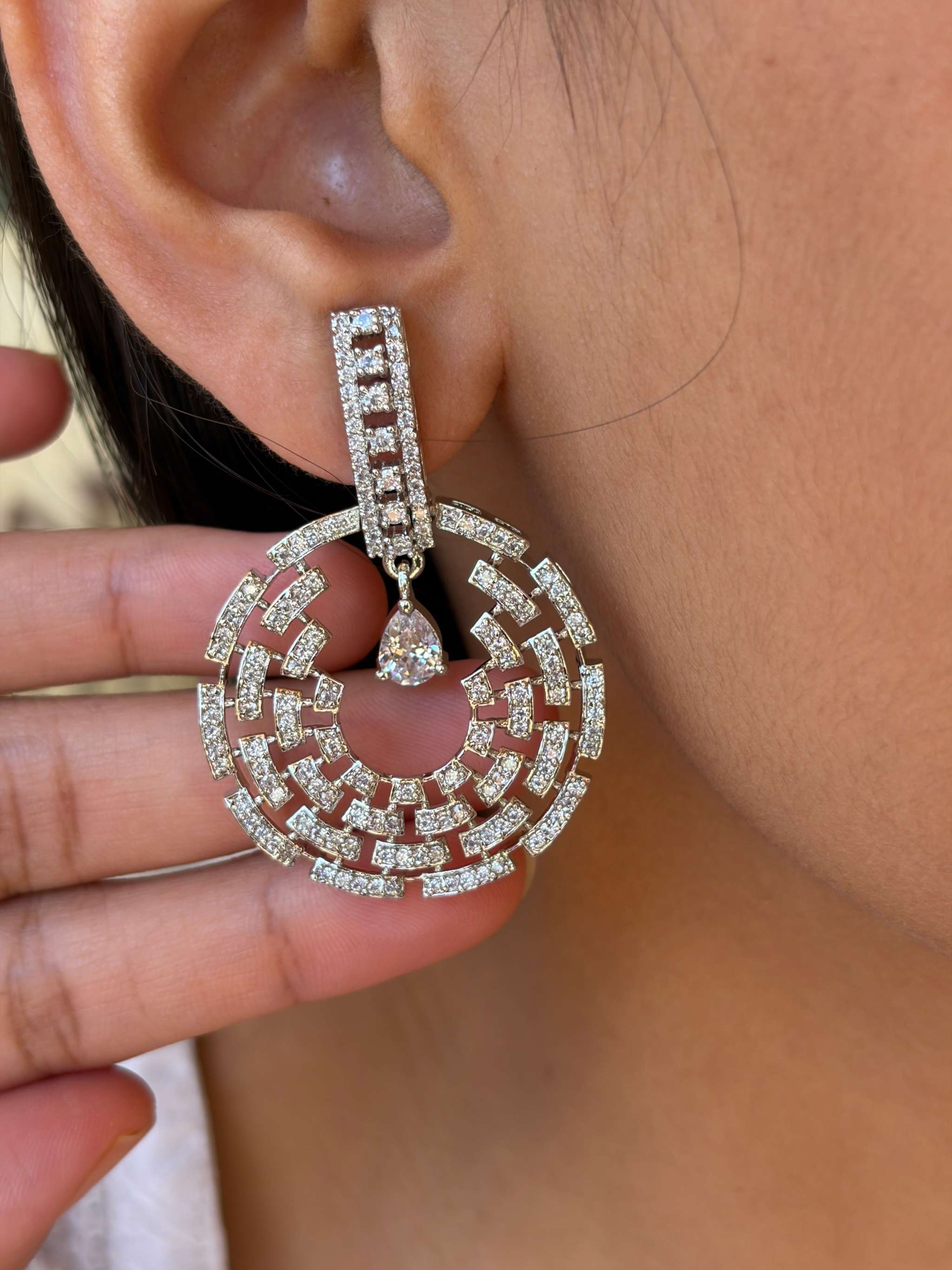 Close-up of a silver Celestial Maze Danglers earring with intricate geometric design and sparkling stones worn on an ear