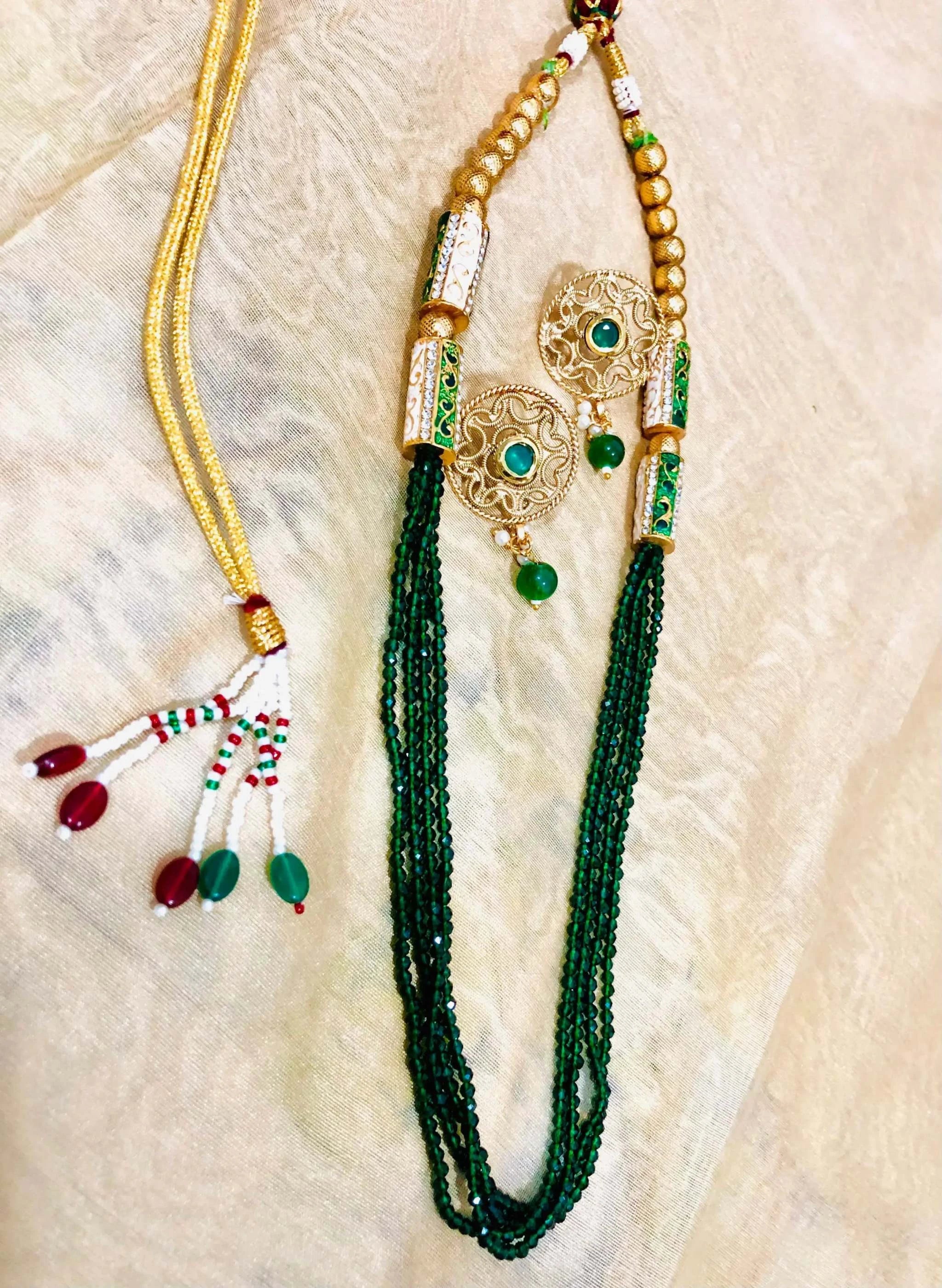 Golden and emerald beaded jewelry set with intricate earrings and matching multi-strand necklace