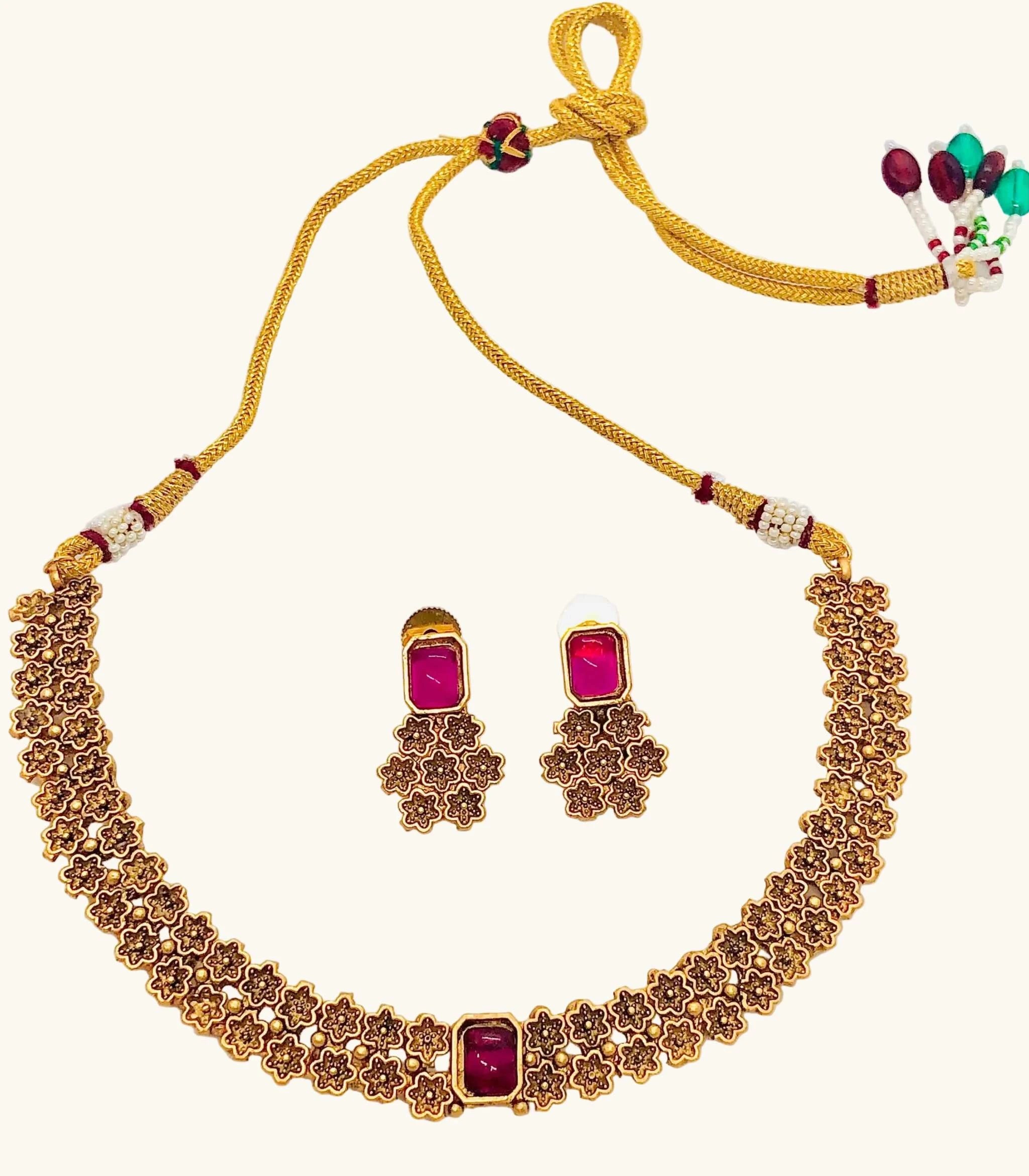 Golden Rajwadi choker necklace set with intricate floral design and matching traditional stud earrings with red stones