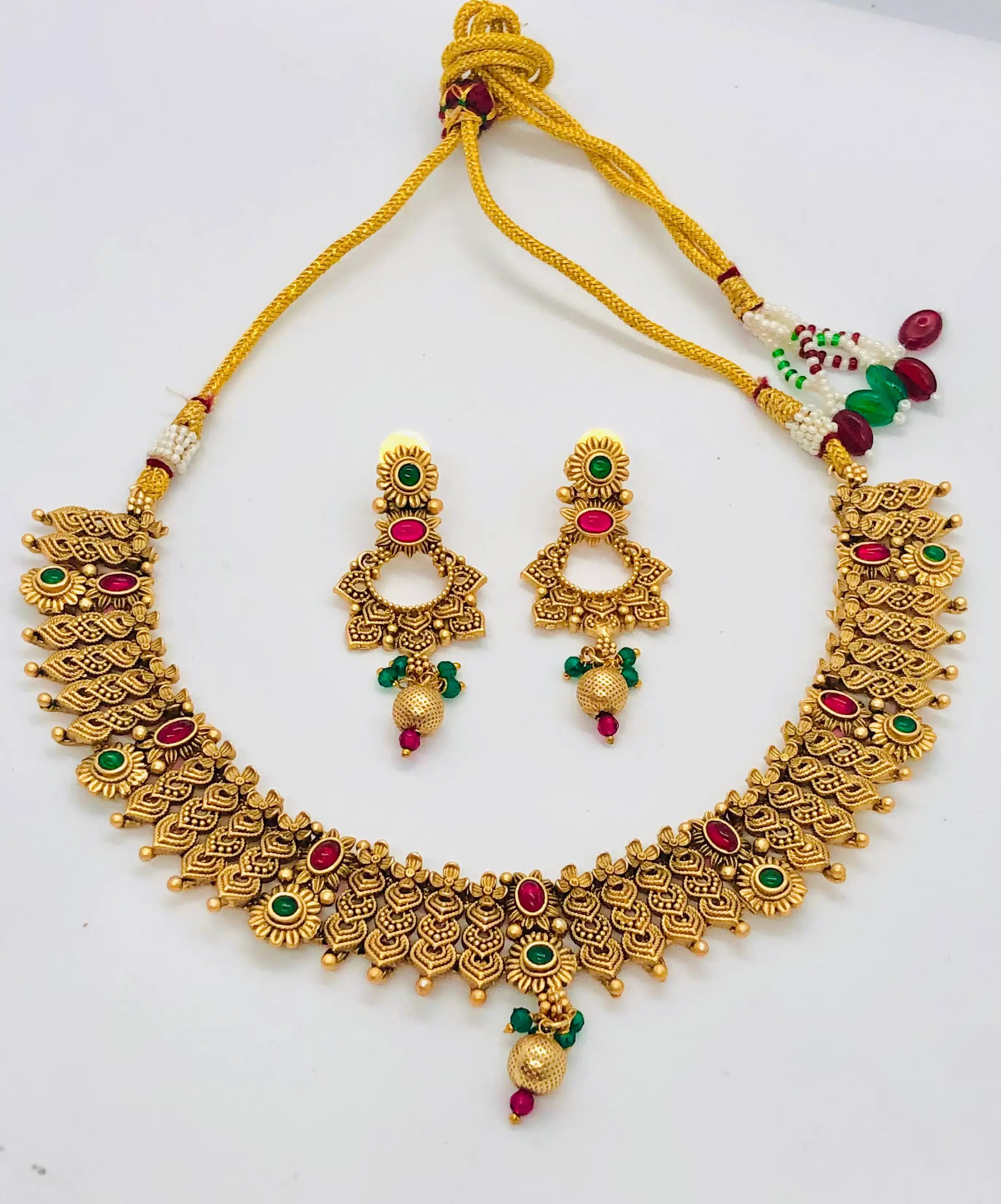 Gold-toned Indian necklace and earring set with red and green stone accents.