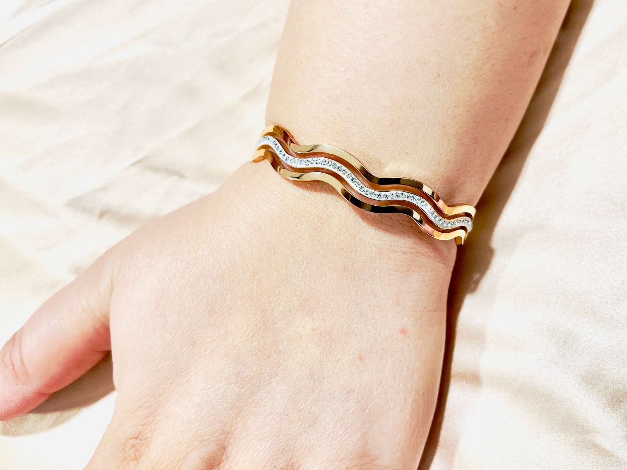 Rose gold diamond waves bracelet with fluid wave design on wrist