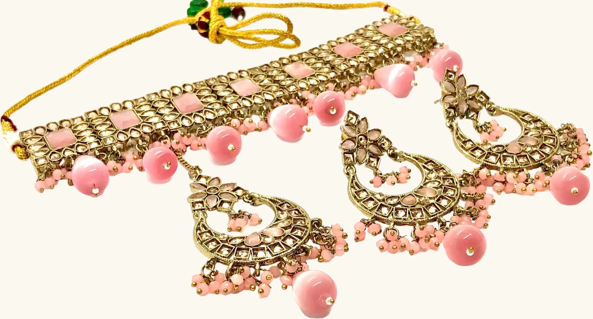 Charming pink Rajwadi choker set with matching maang tikka featuring intricate gold detailing and pink bead accents