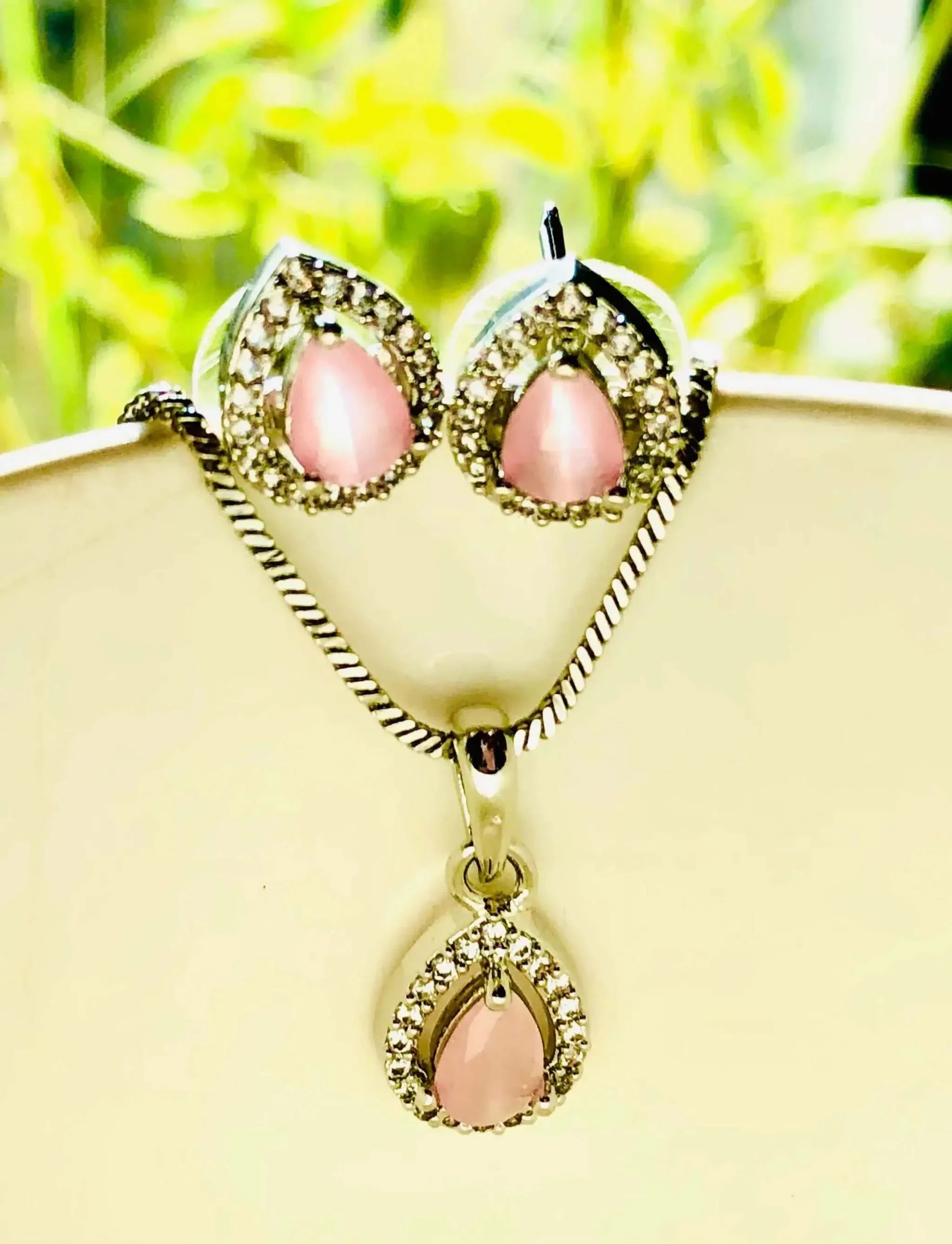 Pink and silver teardrop pendant set with pink stones and silver accents on necklace and earrings