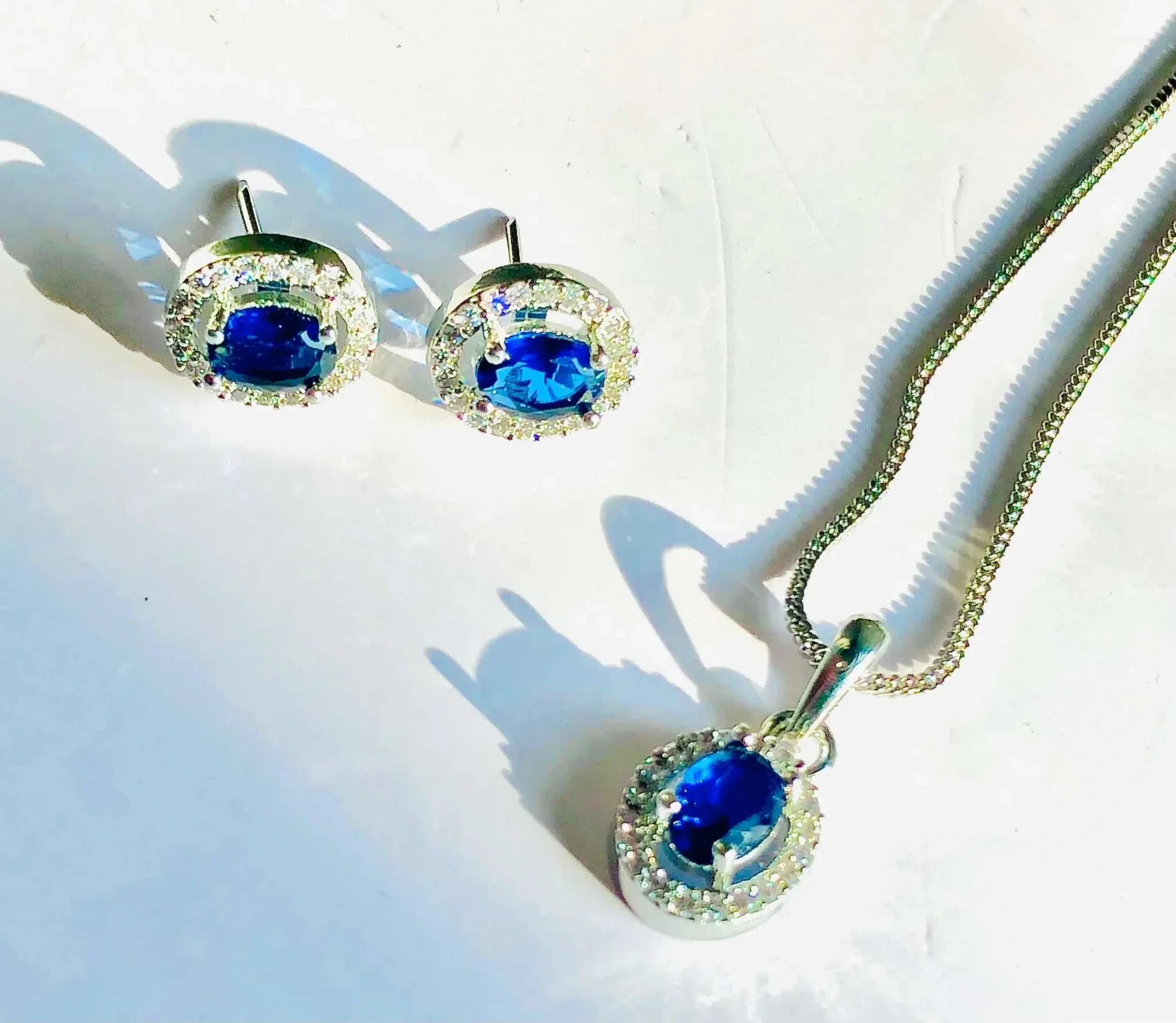 Charming silver blue oval pendant necklace and matching earrings jewelry set with vibrant blue stones and sparkling accents