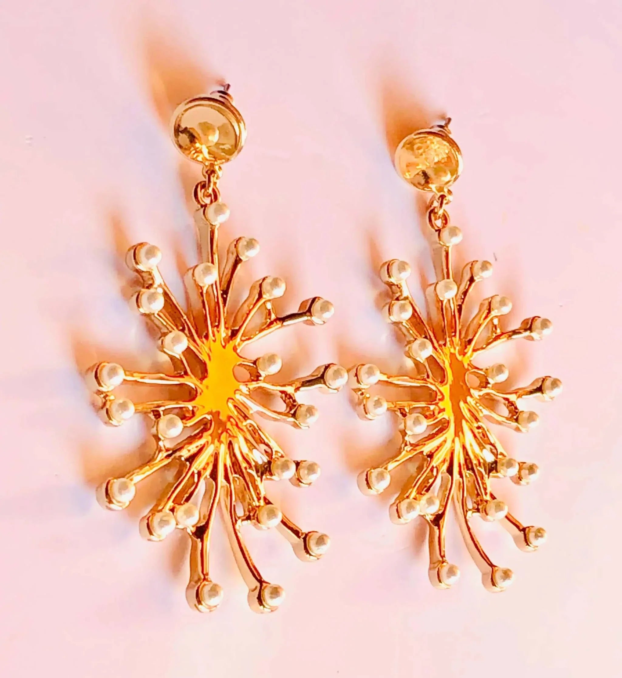 Elegant gold and pearl dangling earrings with a radiant rose gold finish and intricate design