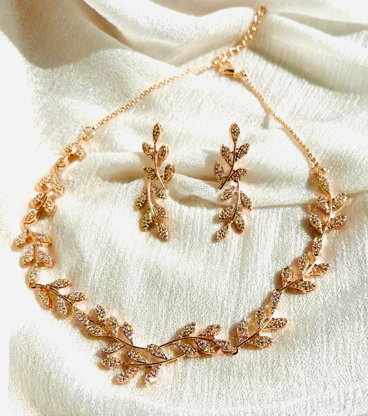 Rosegold Leafy Embrace Necklace Set with delicate leaf motifs on fabric background