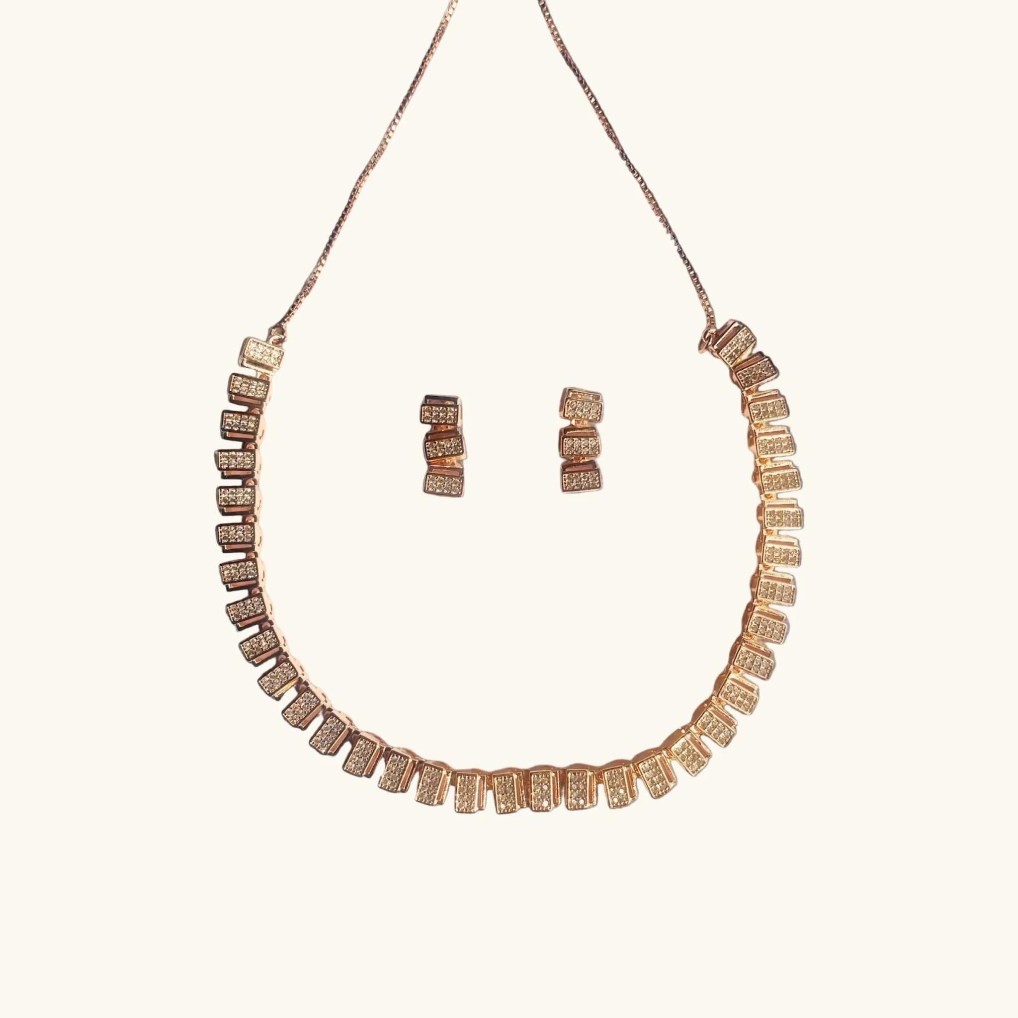 Classic rose gold zircon necklace and earring set displayed on gray fabric surrounded by autumn leaves