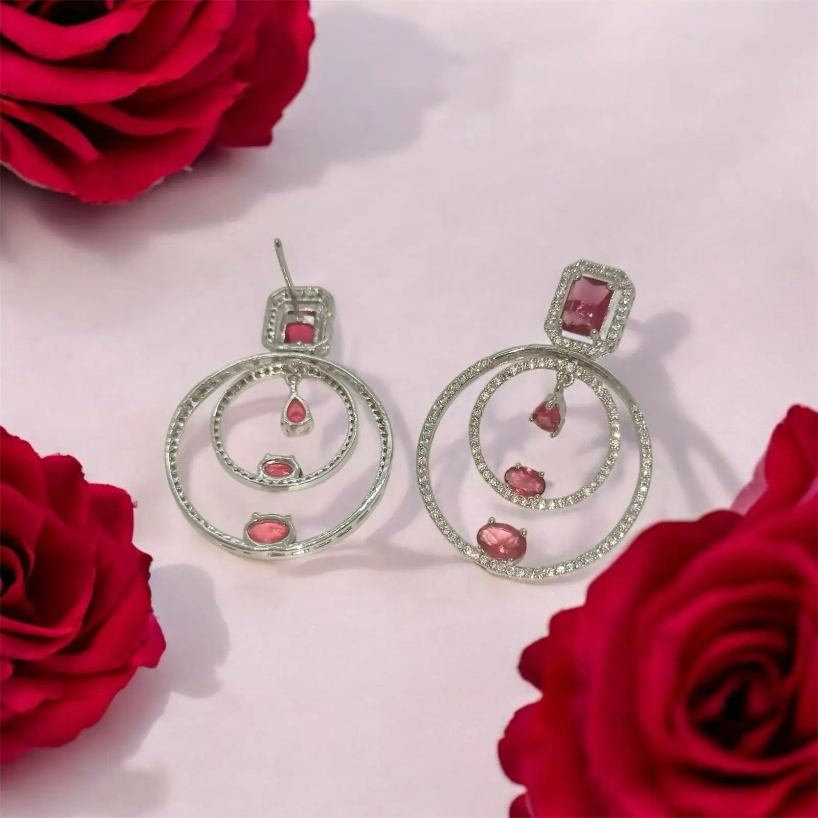 Silver drop earrings with pink tourmaline stones and diamond accents.