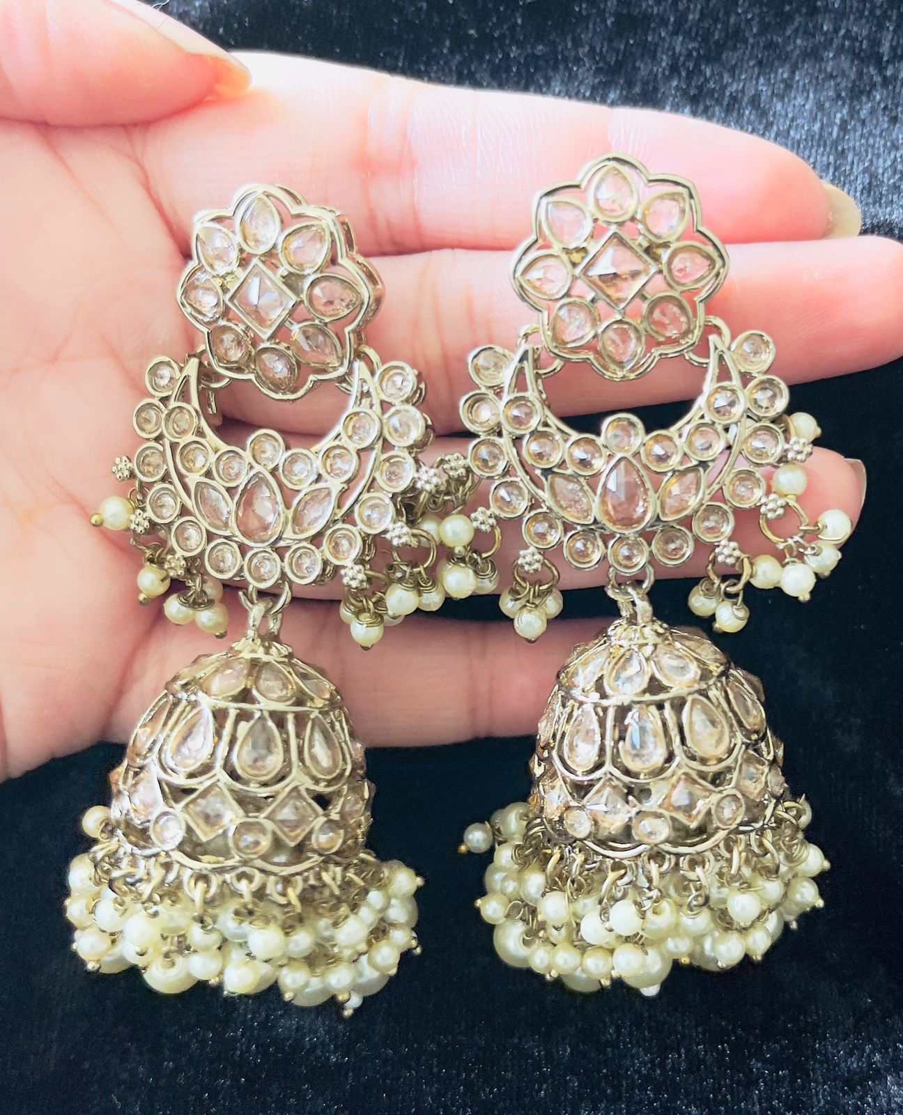 Cascading long jhumkas with intricate tiered design and pearl embellishments for elegant festive wear